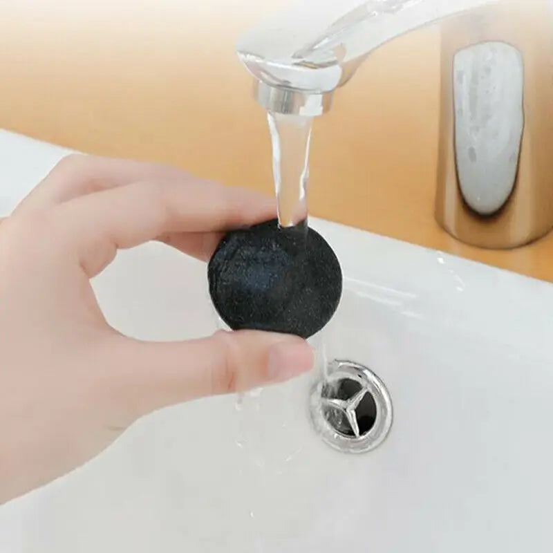 Cleaning a grinder head under running water in a sink.