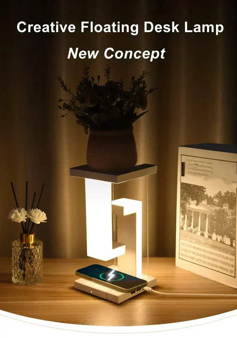 Suspended anti-gravity wireless charging table lamp with LED light and mobile phone charging function on a desk.