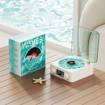 Bluetooth vintage-style player with turquoise wave design, featuring a transparent cover and packaging, on a wooden table.